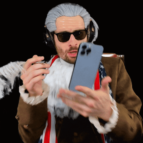 a man in a wig and sunglasses is holding a phone