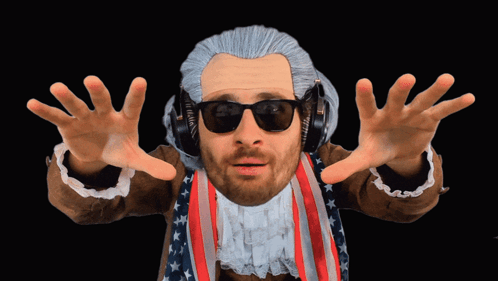 A Man In A Wig And Sunglasses Is Wearing Headphones And An American Flag Jacket GIF