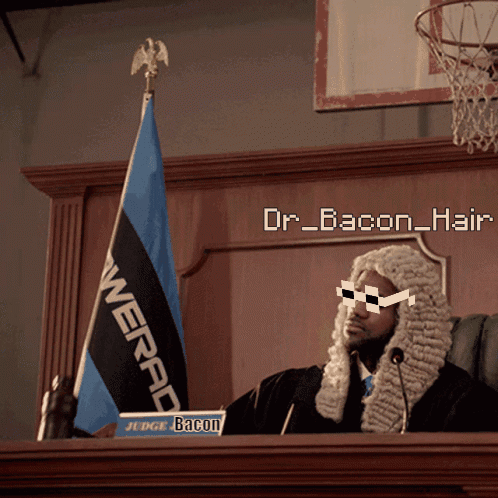 A Man In A Wig Is Sitting At A Podium With A Sign That Says " Judge Bacon " GIF