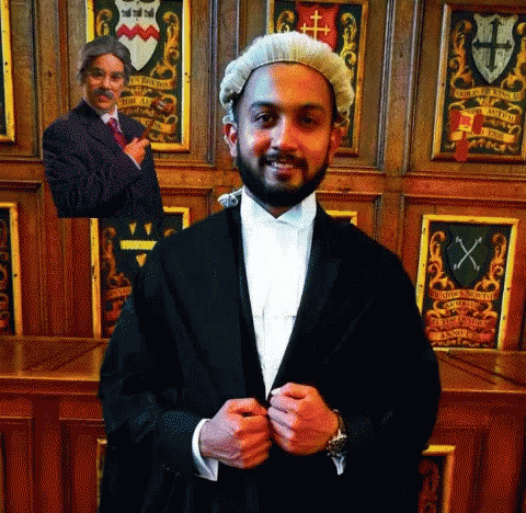 a man in a wig is standing in front of a coat of arms