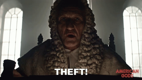A Man In A Wig Says " Theft " In Front Of An American Gods Poster GIF
