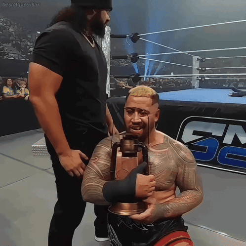 A Man In A Wrestling Ring Holds A Lantern In Front Of A Gm Logo GIF