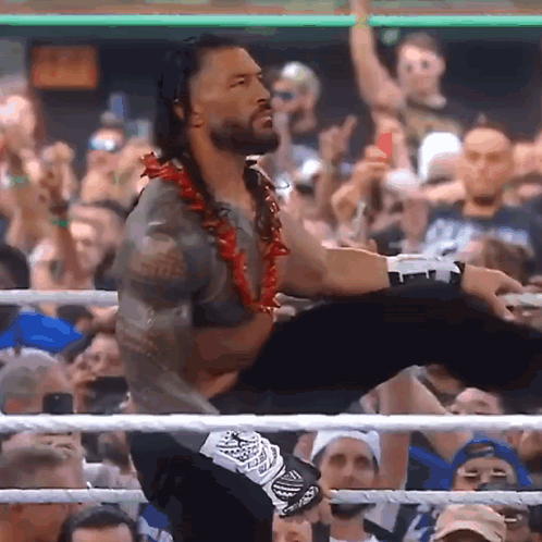 A Man In A Wrestling Ring Holds Another Man 'S Leg Up In The Air GIF