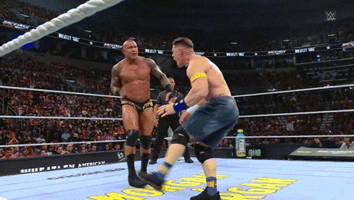 A Man In A Wrestling Ring With A Gatorade Bottle Behind Him GIF