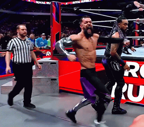 A Man In A Wrestling Ring With A Referee And A Sign That Says Royal Rumble On It GIF