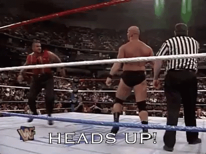 A Man In A Wrestling Ring With A Referee Standing Behind Him . GIF
