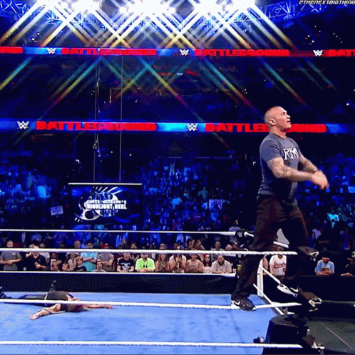A Man In A Wrestling Ring With A Sign That Says Battleground In The Background GIF