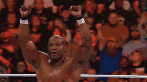 A Man In A Wrestling Ring With His Arms In The Air GIF
