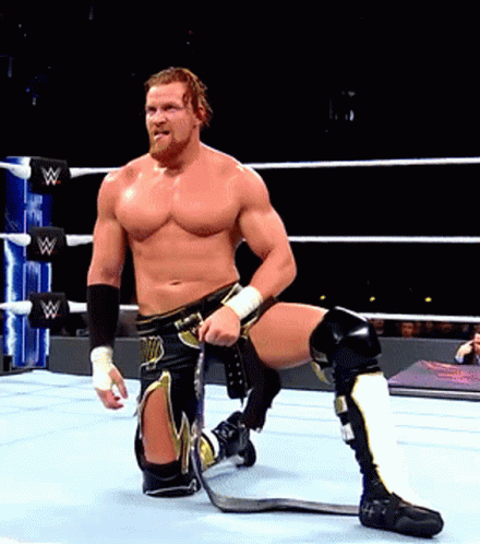 a man in a wrestling ring with the letter w on the ring ropes