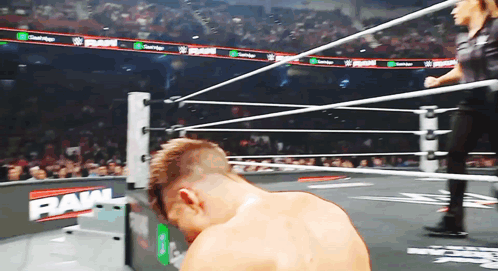 a man in a wrestling ring with the word raw on the wall