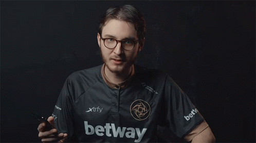 A Man In A Xtrfy Shirt Is Holding A Cell Phone GIF