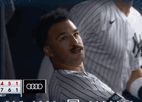 A Man In A Yankees Jersey Is Looking At The Scoreboard GIF