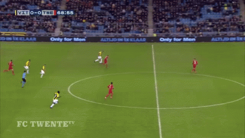 A Man In A Yellow And Black Striped Shirt Is Jumping In The Air In Front Of A Large D GIF