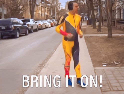 A Man In A Yellow And Blue Suit Is Running Down A Sidewalk With The Words Bring It On GIF