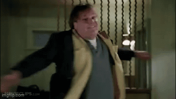 A Man In A Yellow Coat Is Dancing In A Room . GIF