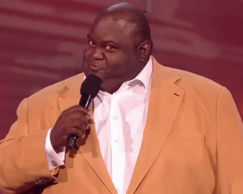 A Man In A Yellow Jacket Holding A Microphone GIF