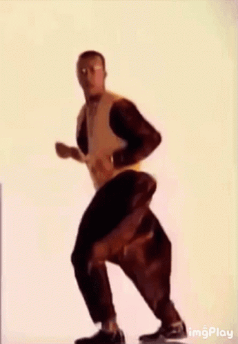 A Man In A Yellow Jacket Is Dancing With His Arms Outstretched . GIF