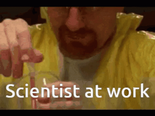 A Man In A Yellow Jacket Is Holding A Beaker With The Words Scientist At Work Written On It GIF