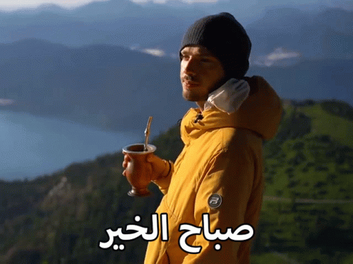 A Man In A Yellow Jacket Is Holding A Cup With A Straw And The Words " صباح الخير " Written On The Bottom GIF