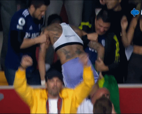 a man in a yellow jacket is holding a man in a white tank top with the number 8 on it