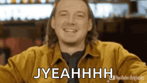 A Man In A Yellow Jacket Is Smiling And Says Jyeahhhh . GIF