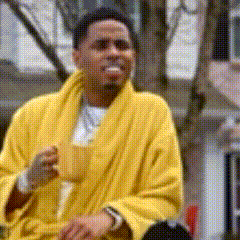 A Man In A Yellow Robe Is Drinking From A Cup GIF