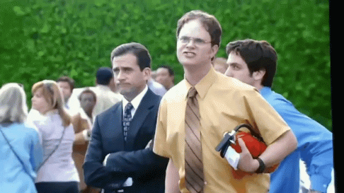 A Man In A Yellow Shirt And Tie Holds A Red Fire Extinguisher GIF