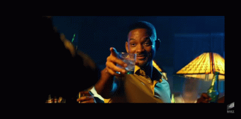 A Man In A Yellow Shirt And Tie Is Holding A Glass Of Water GIF