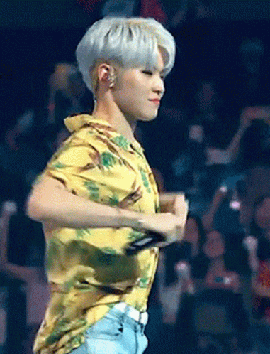 A Man In A Yellow Shirt Is Dancing On A Stage In Front Of A Crowd GIF