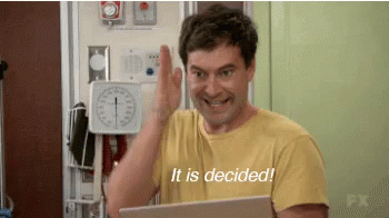 A Man In A Yellow Shirt Is Giving A High Five While Holding A Laptop And Says It Is Decided . GIF