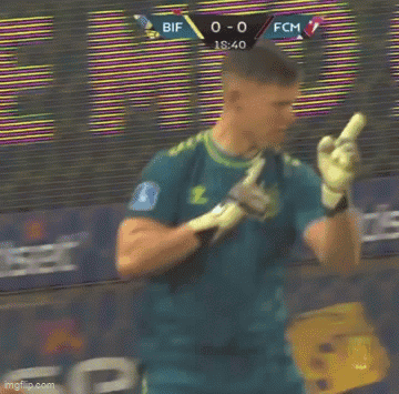 A Man In A Yellow Shirt Is Holding Another Man 'S Hand In Front Of A Soccer Net . GIF
