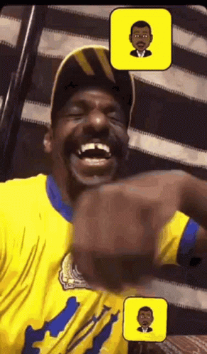A Man In A Yellow Shirt Is Laughing With A Picture Of A Man In A Suit Behind Him GIF