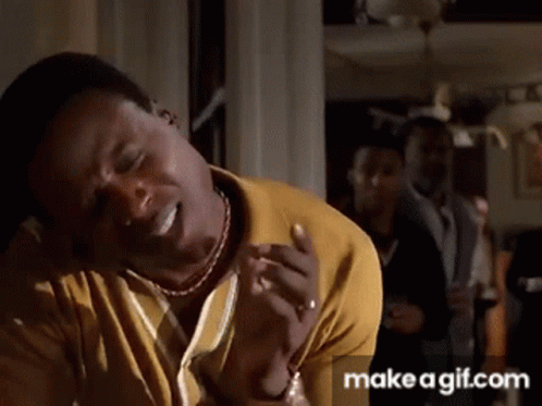 A Man In A Yellow Shirt Is Making A Funny Face With His Eyes Closed GIF