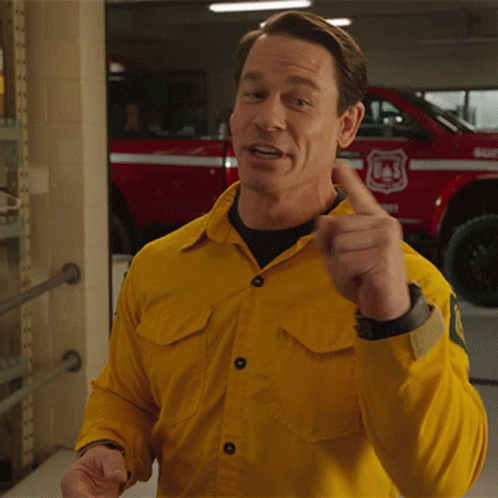 A Man In A Yellow Shirt Is Pointing At Something In Front Of A Red Truck That Says Usf GIF