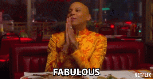 A Man In A Yellow Shirt Is Sitting At A Table In A Restaurant With His Hands Folded . GIF