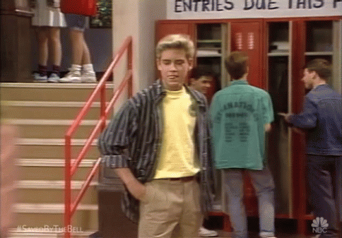 A Man In A Yellow Shirt Is Standing In Front Of A Sign That Says Entries Due This GIF