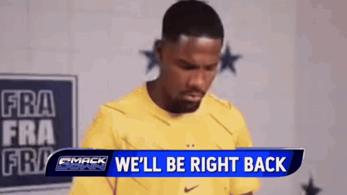 A Man In A Yellow Shirt Is Standing In Front Of A Sign That Says We 'Ll Be Right Back GIF