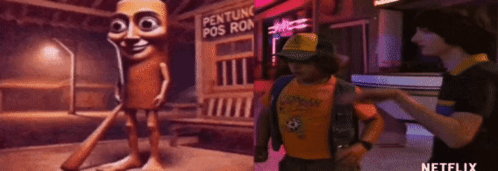 A Man In A Yellow Shirt Is Standing Next To A Cartoon Character In Front Of A Sign That Says Penture Pos Ron . GIF