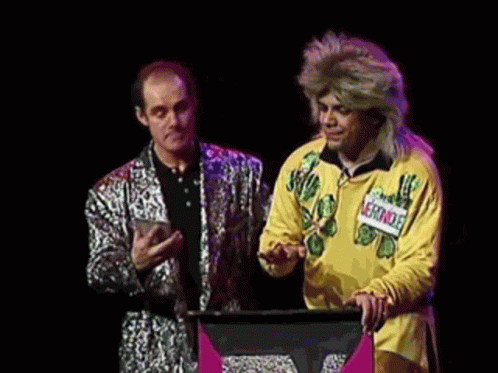 A Man In A Yellow Shirt Is Standing Next To A Man In A Silver Suit And Says " Vous Pouvez Repeter La Question " GIF