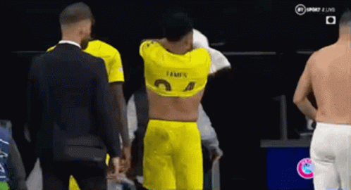 A Man In A Yellow Shirt Is Standing Next To A Man In A Suit . GIF
