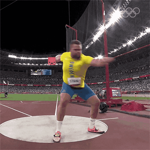 A Man In A Yellow Shirt Is Throwing A Disc GIF