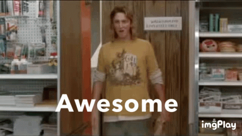 A Man In A Yellow Shirt Standing In Front Of A Sign That Says Awesome GIF