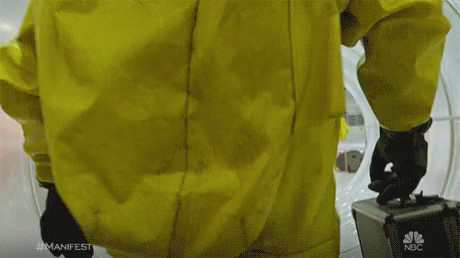 A Man In A Yellow Suit Is Holding A Briefcase With Nbc On It GIF