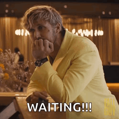 A Man In A Yellow Suit Is Sitting At A Table And Waiting !!! GIF