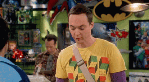 A Man In A Yellow T-Shirt Is Standing In A Room With A Batman Sign . GIF