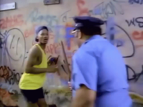 A Man In A Yellow Tank Top Is Standing Next To A Police Officer . GIF