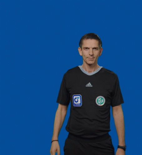 a man in an adidas shirt holds up a yellow card against a blue background