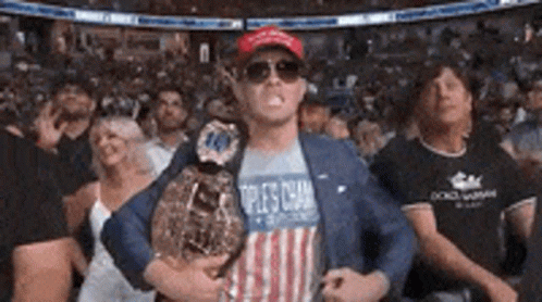 A Man In An American Flag Shirt Is Holding A Boxing Championship Belt . GIF
