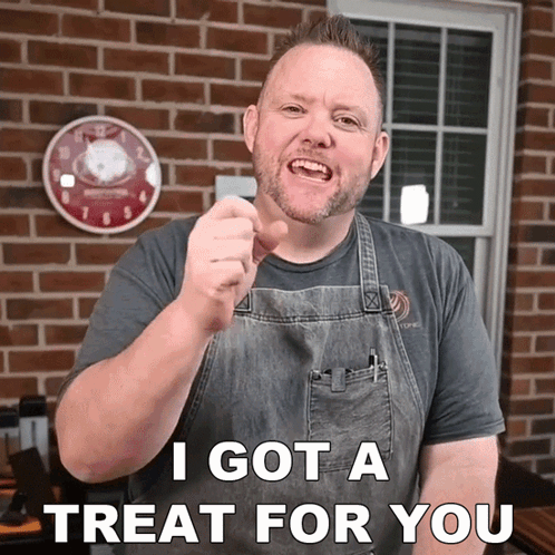 A Man In An Apron Is Pointing At The Camera With The Words I Got A Treat For You Below Him GIF