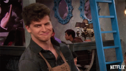 A Man In An Apron Is Smiling In Front Of A Blue Ladder That Says Netflix On It GIF